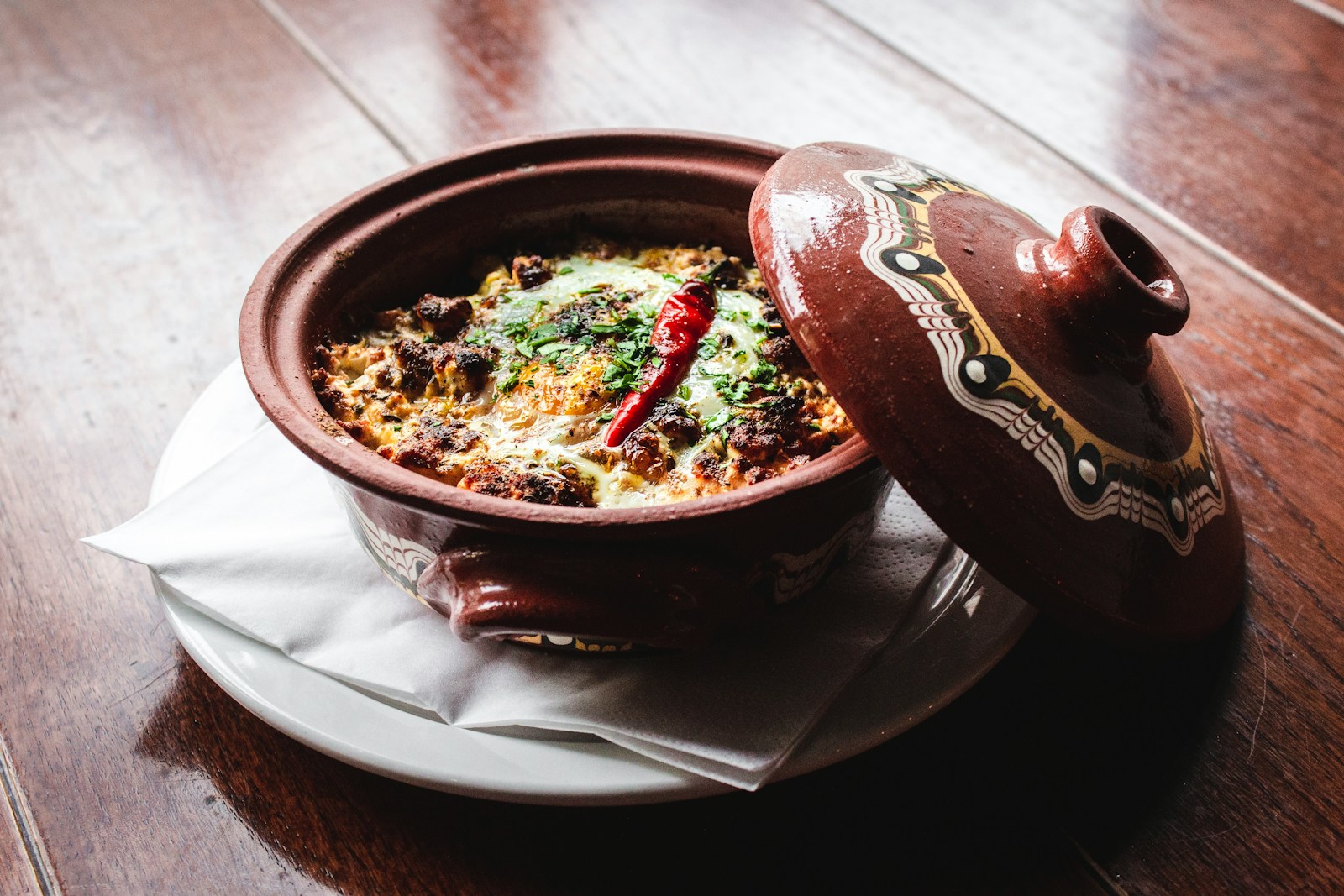 round brown and white ceramic pot with food