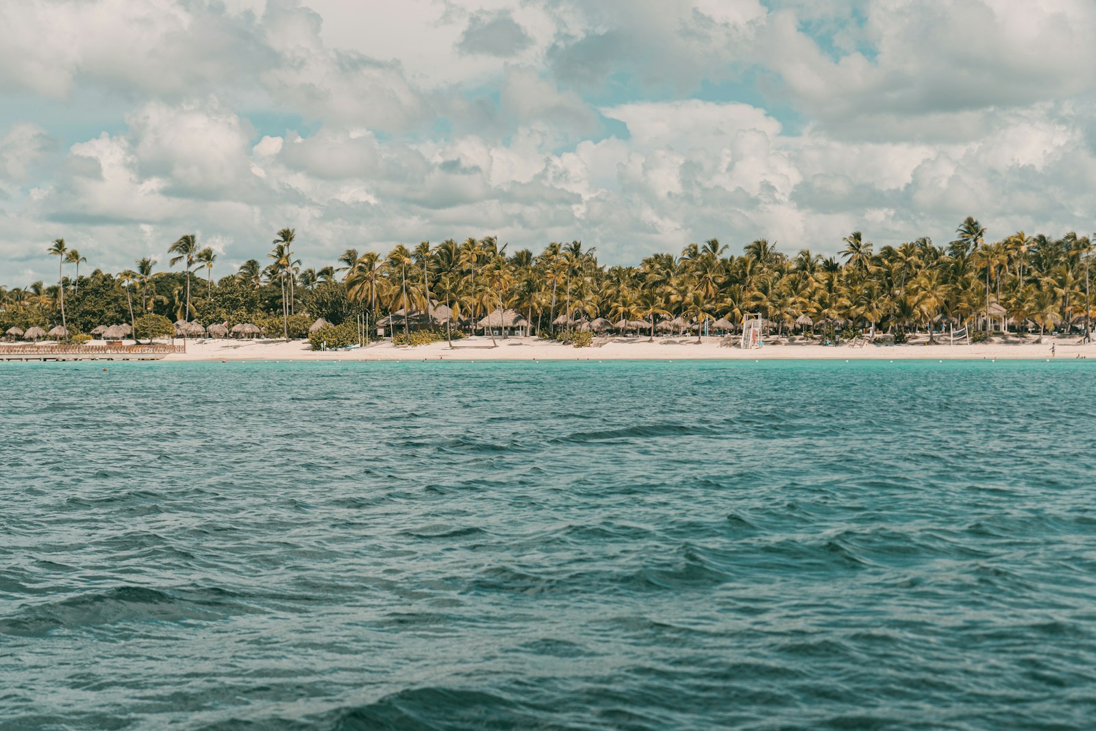 green trees on island surrounded by water under white clouds during daytime