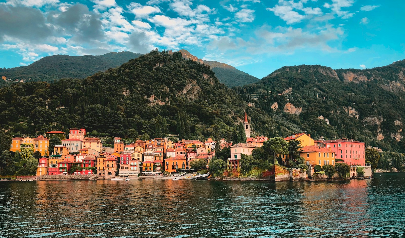 houses near body of water and mountain during daytime