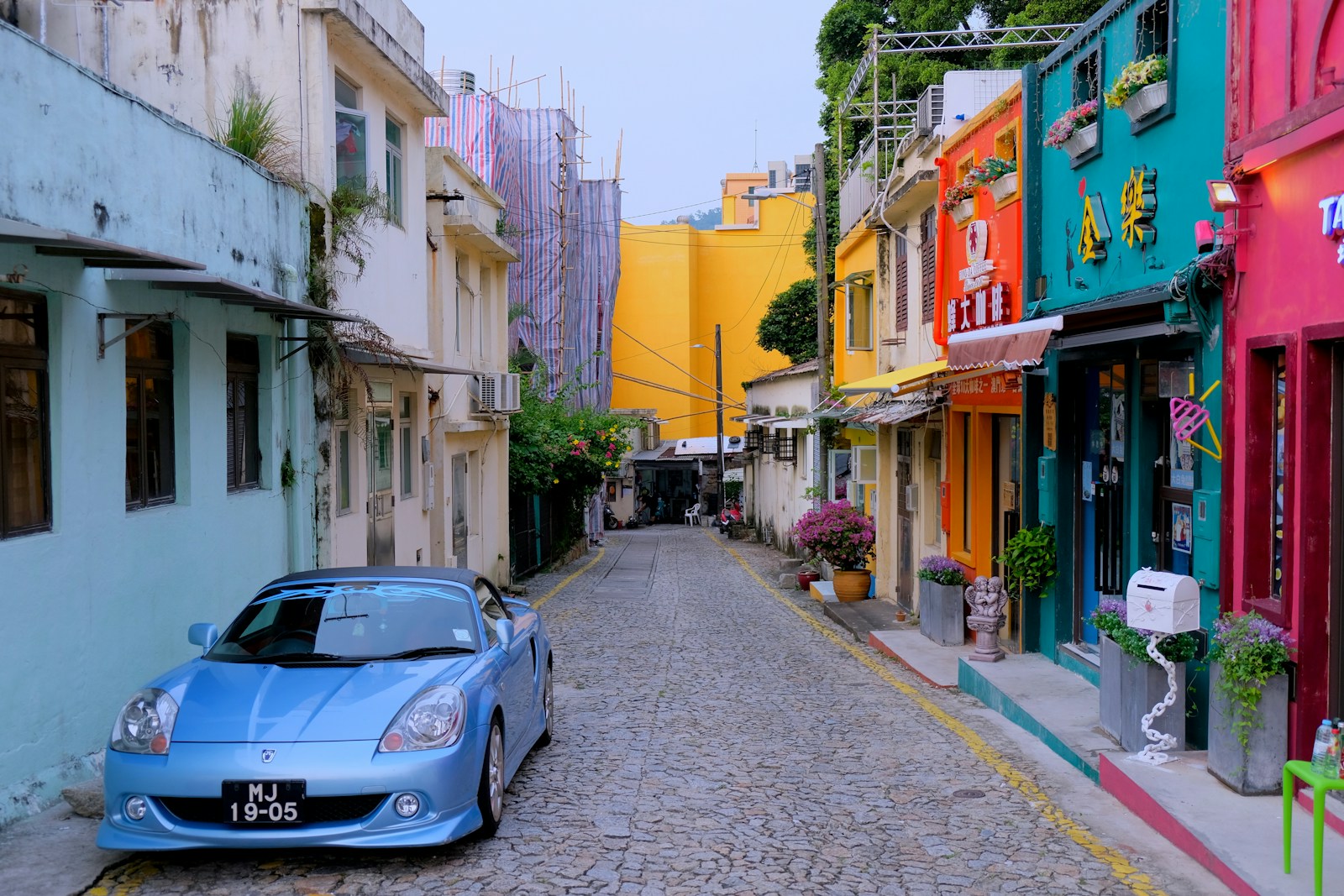 blue convertible coupe parked in front of blue house