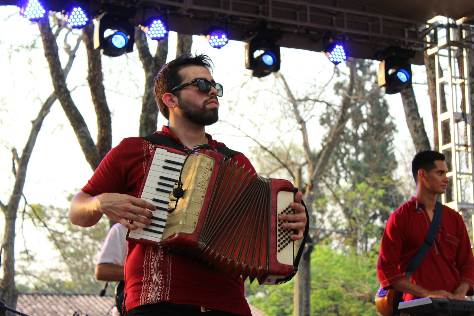 man playing red and white musical instrument