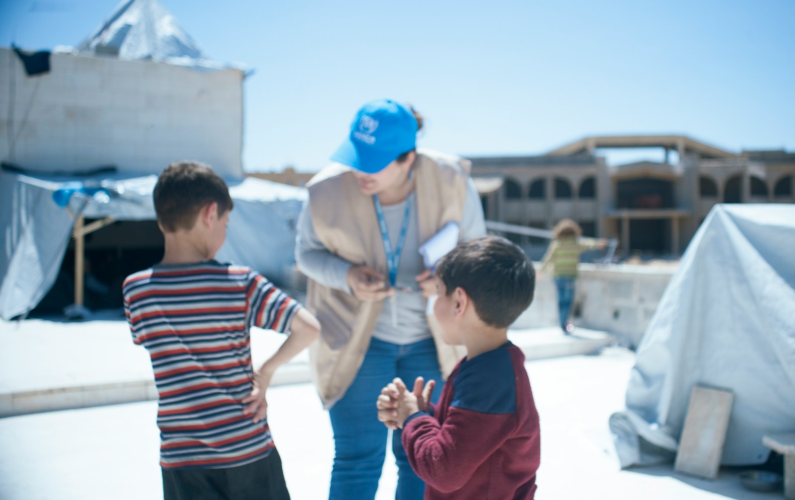 a woman standing next to two small boys