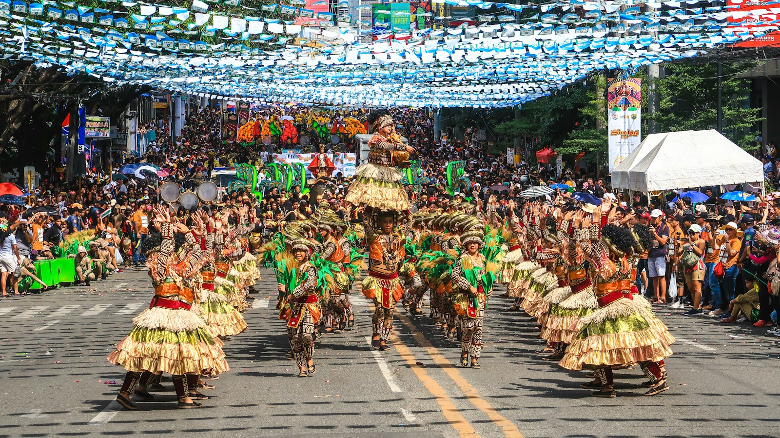 people in green and brown traditional dress walking on street during daytime